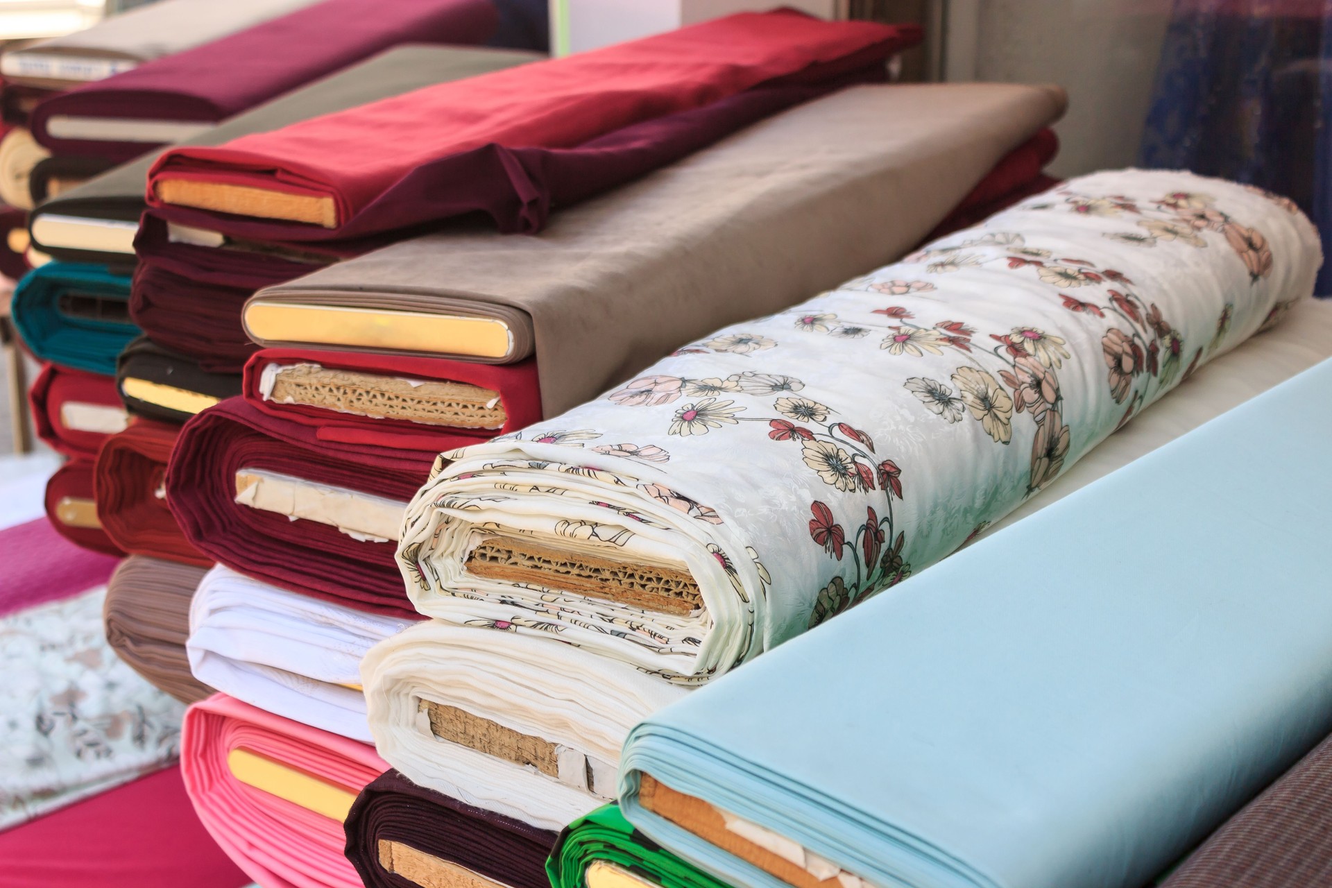 Piles of colorful fabrics for sale at a shop